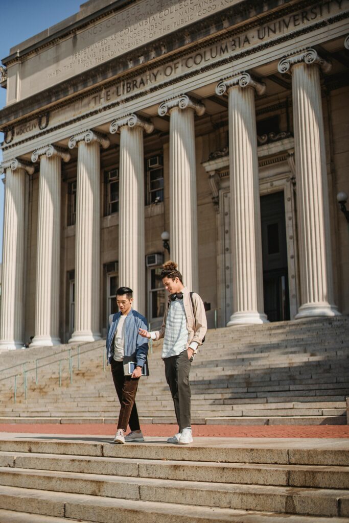 Two Men Standing Outside A University Building